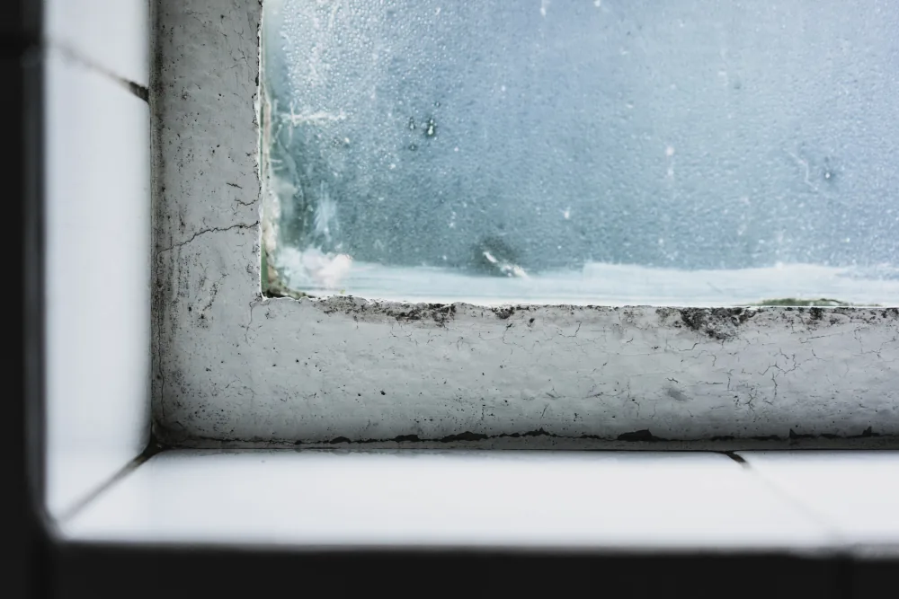 Altes Fenster mit sichtbarem Spalt am Rahmen und Zugluft im Wohnraum im Herbst